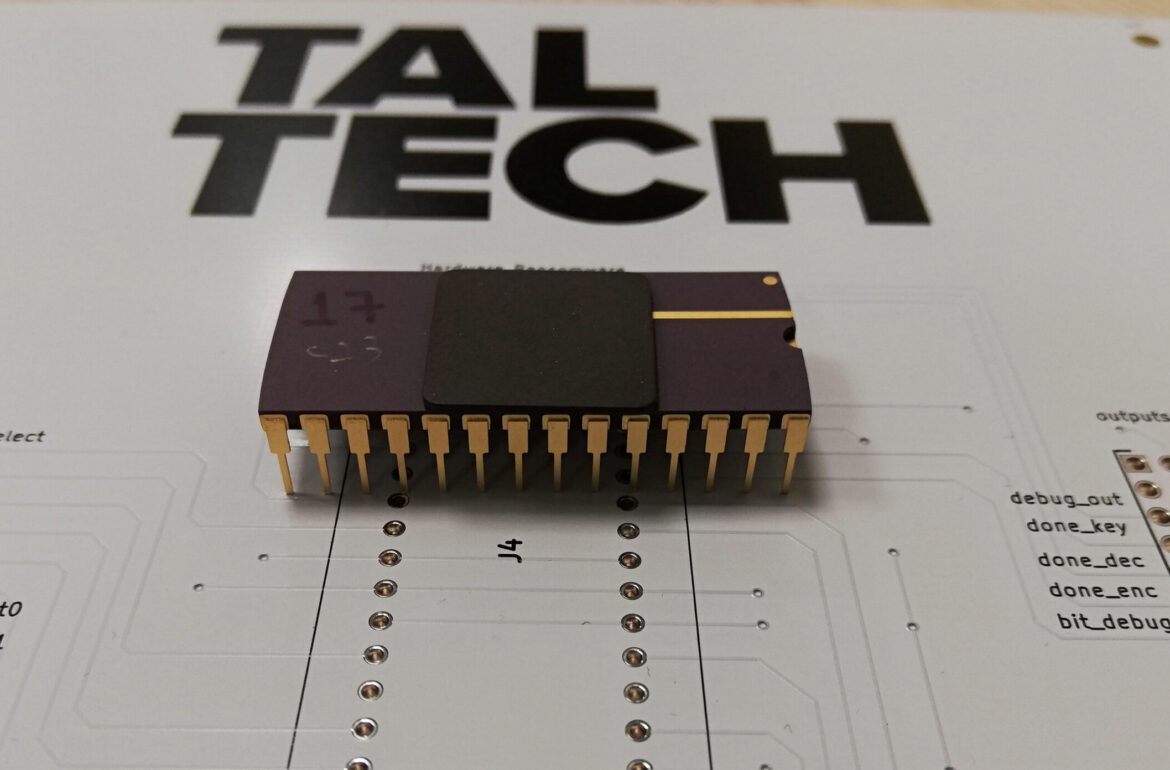 Photograph of the packaged chip. In the background a Printed Circuit Board utilized for bringing up the chip in the laboratory. Photo credit: Samuel  Pagliarini
